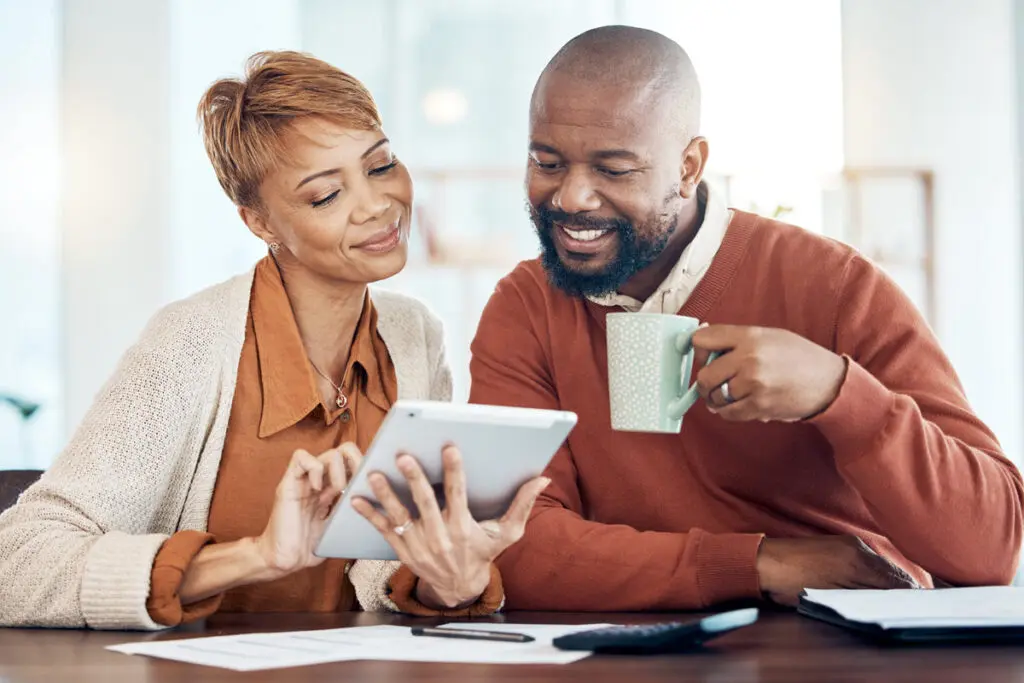 Comparing Top $50,000 Personal Loans A couple using a tablet to compare top $50,000 personal loan offers.