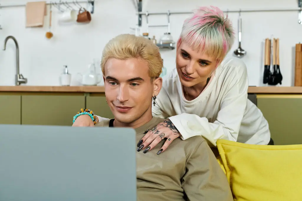 A couple using a laptop to compare top $6,000 personal loan offers.