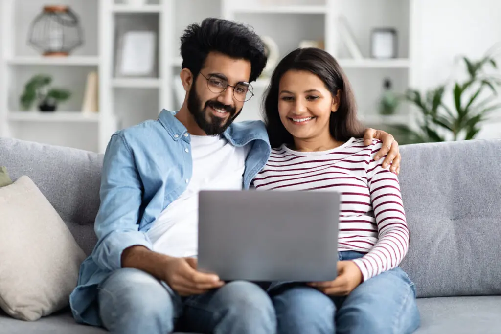 A couple using a laptop to compare home improvement personal loan offers.