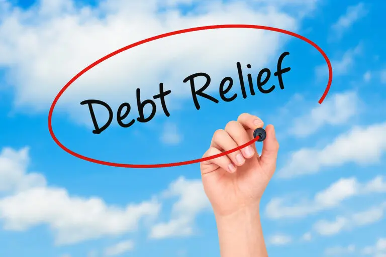 Hand circling debt relief with blue sky and clouds in the background.