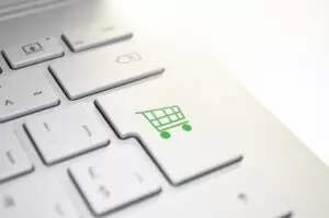 Online shopping cart design on computer keyboard key.