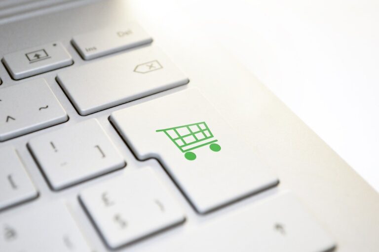 Online shopping cart design on computer keyboard key.