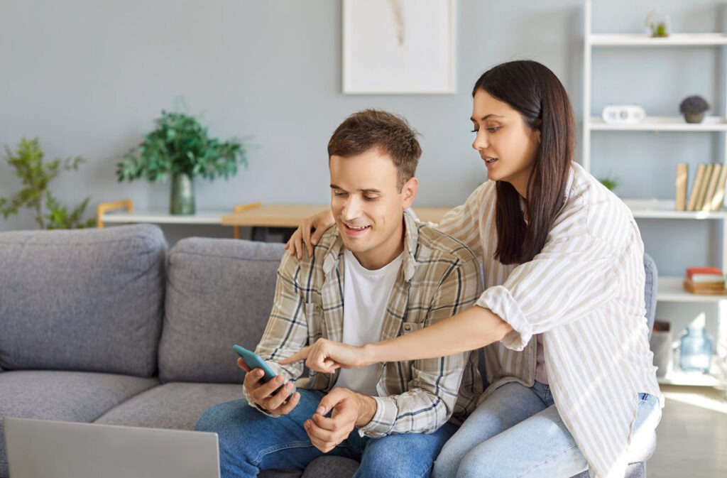 Comparing Top $25,000 Personal Loans A couple using a smartphone to compare top $25,000 personal loan offers.