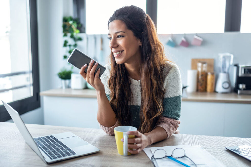 A person using a smartphone and laptop to compare top $5,000 personal loan offers.