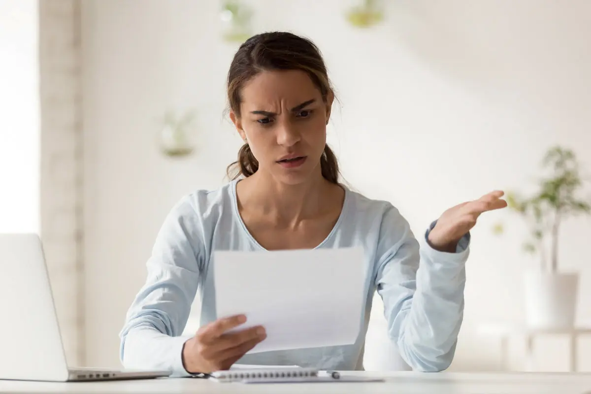A person sitting at a desk looks at a loan rejection letter while considering home equity agreement alternatives.