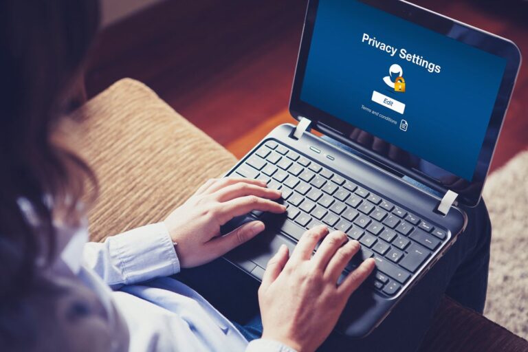 Person reviewing privacy settings on a laptop to protect their finances during a digital cleanup.