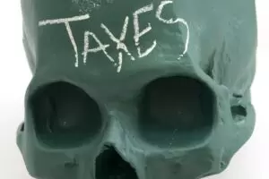Taxes written on green skull.