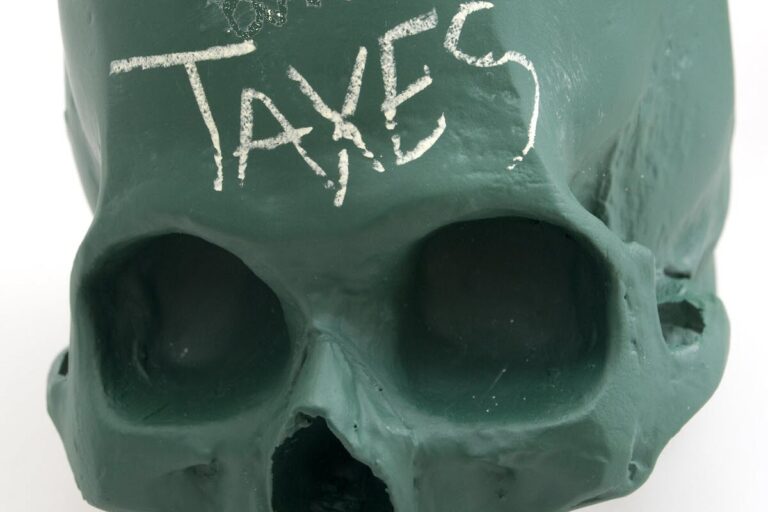 Taxes written on green skull.