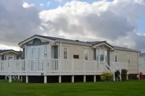 White metal mobile home on grass.