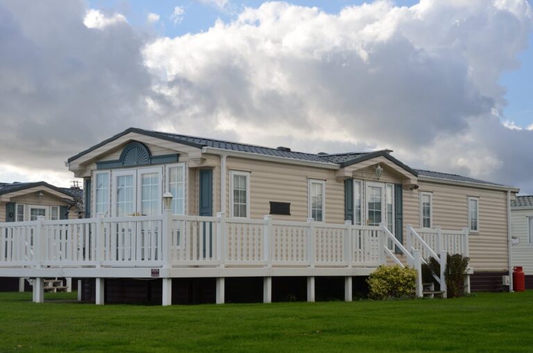 White metal mobile home on grass.