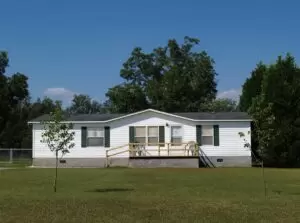 White single-wide mobile home on land lot.